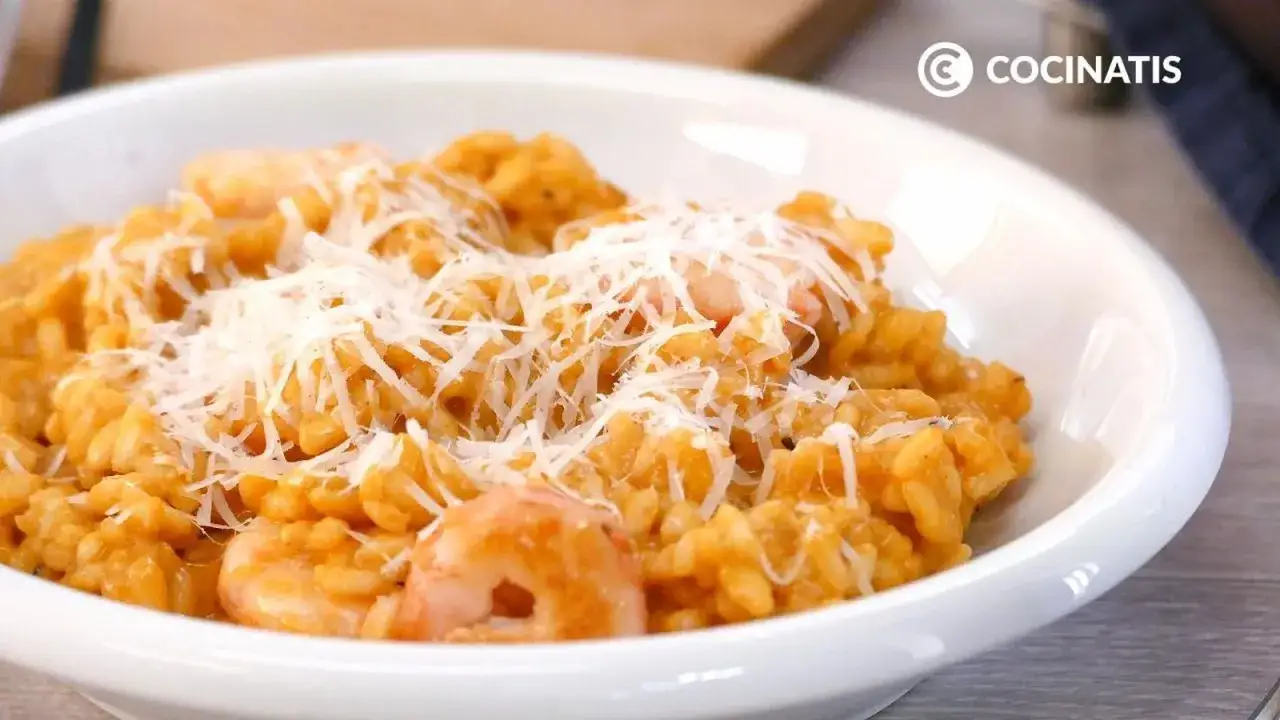 Un cremoso risotto de gambas, cubierto con queso rallado, listo para disfrutar.