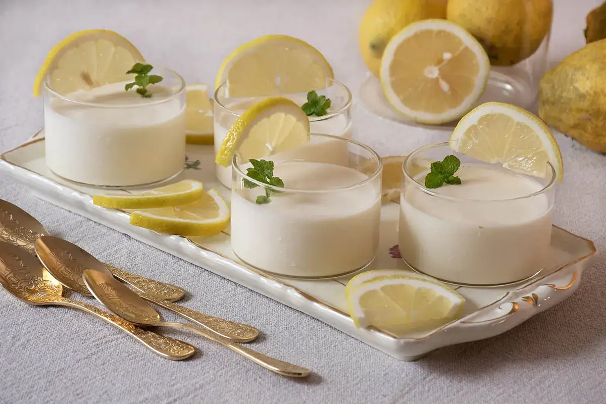 Delicioso postre de limón, perfecto para tu próxima receta de lemon curd. Servido en vasitos con rodajas de limón y menta.