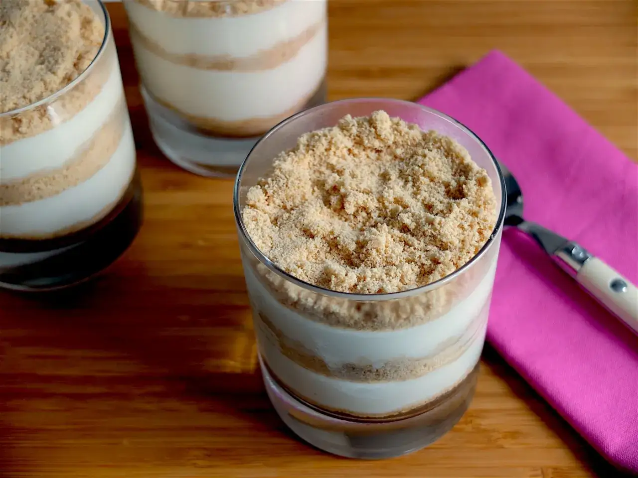 Postres en capas en vasos, con crema y galleta triturada, como una deliciosa baba de camelo.