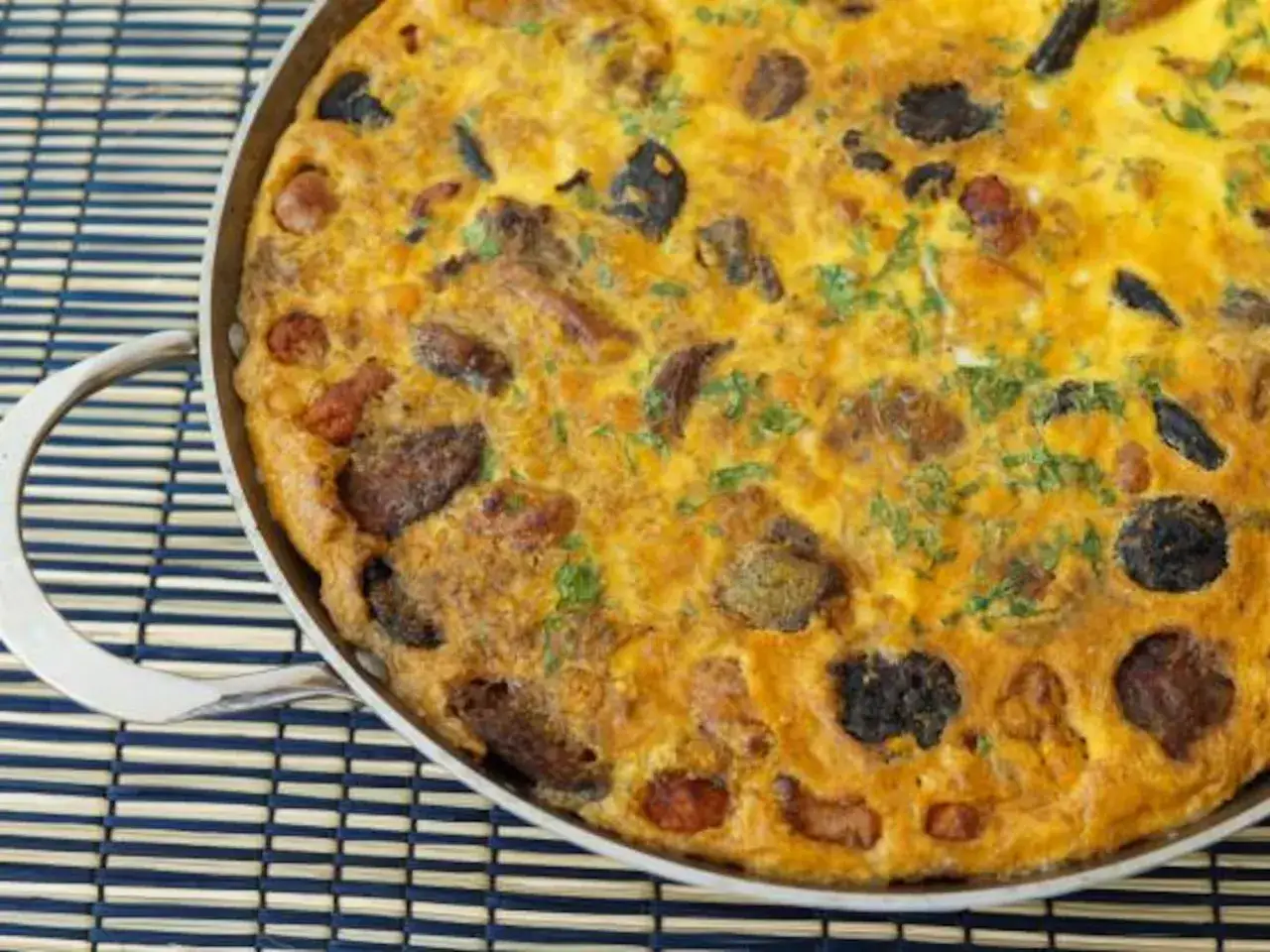Arroz con costra reci&eacute;n hecho, dorado y apetitoso, con trozos de carne y aceitunas negras, listo para servir.