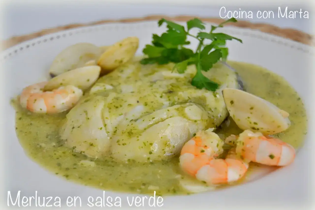 Merluza en salsa verde con gambas y almejas, decorada con perejil fresco. Un plato delicioso y lleno de sabor.