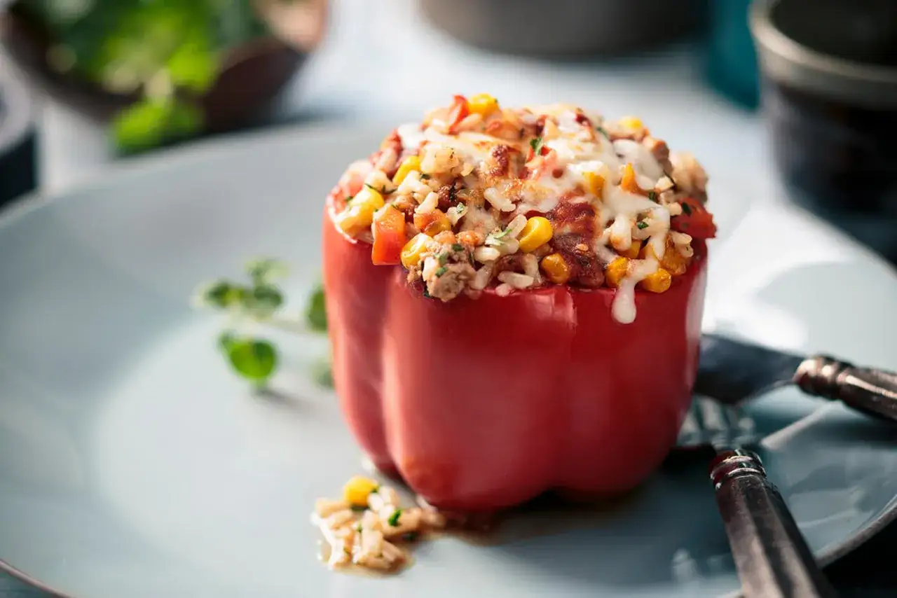 Pimiento rojo relleno de arroz, carne picada, maíz y queso gratinado. Un plato casero y delicioso.
