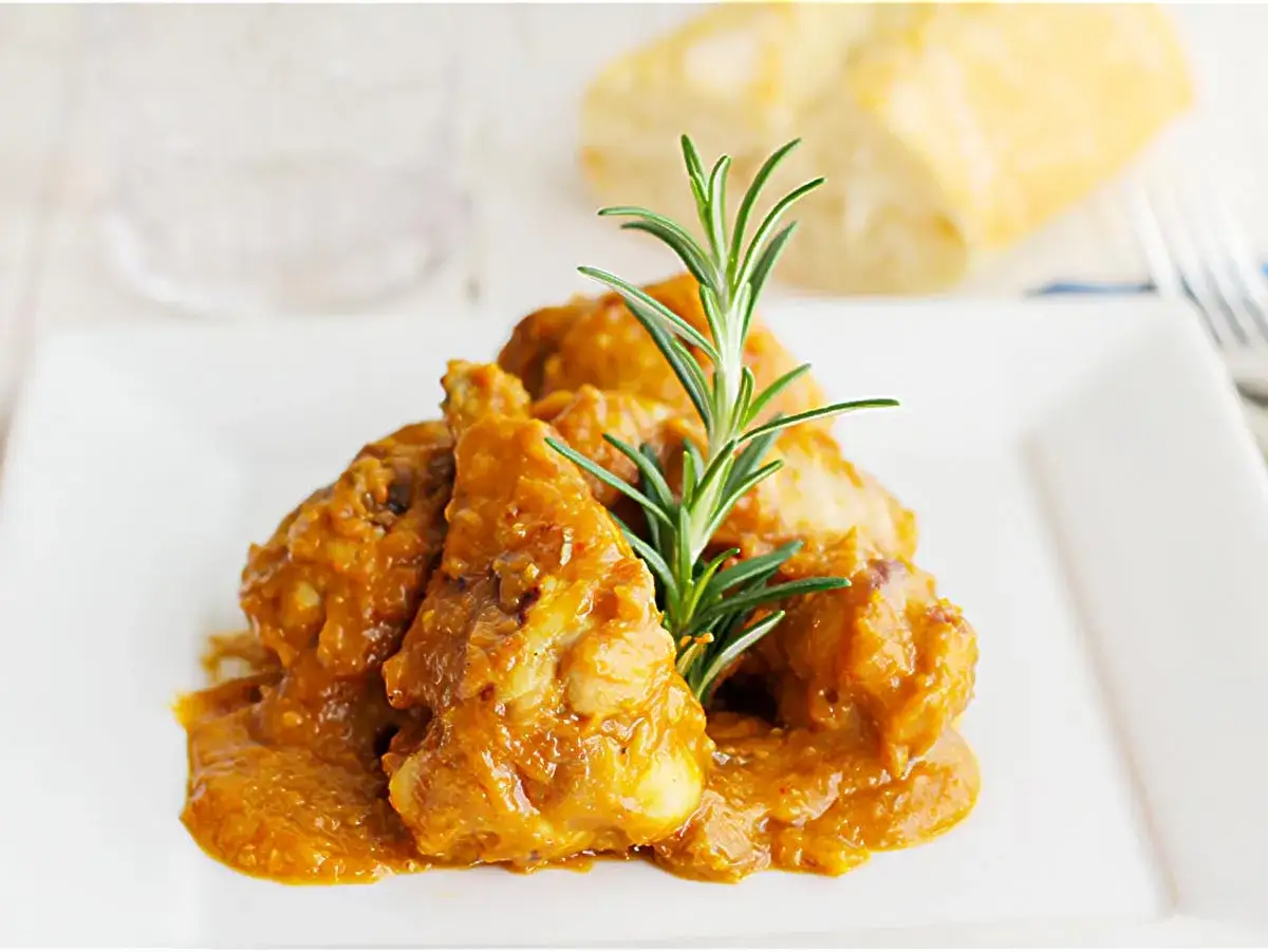 Pollo almendras en salsa cremosa, preparado en Thermomix, servido con romero y pan.
