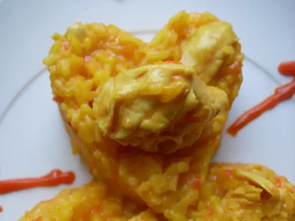 Arroz amarillo con pollo, preparado en Thermomix, con trozos de pollo tierno y un toque de salsa roja.