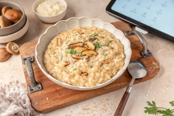 Delicioso risotto de setas hecho en Thermomix, servido en un cuenco blanco con láminas de shiitake y perejil fresco.
