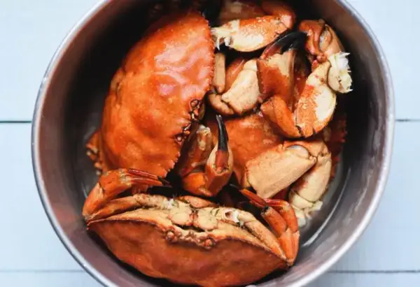 Un cuenco lleno de buey de mar cocido, con sus caparazones naranjas y pinzas visibles.