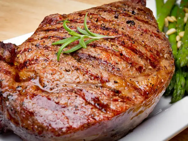 Jugoso filete de ternera a la parrilla con romero y espárragos verdes.