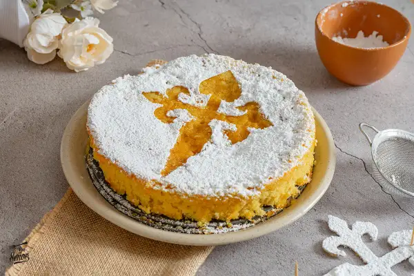 Tarta de Santiago espolvoreada con azúcar glas, con la Cruz de Santiago marcada. Un postre tradicional listo para disfrutar.