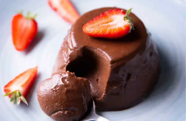 Delicioso flan de chocolate cremoso, decorado con fresas frescas. ¡Un postre irresistible!