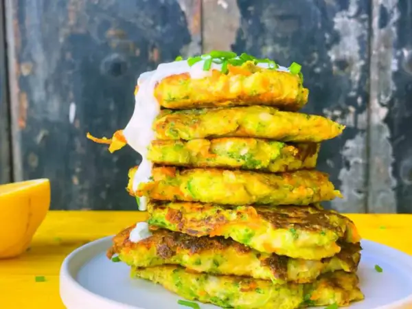Torre de tortitas de brócoli y zanahoria, cubiertas con crema y cebollino.