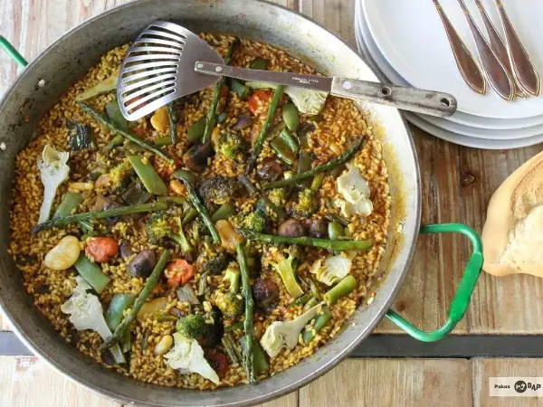 Un delicioso arroz con verduras, lleno de brócoli, espárragos y alcachofas, listo para servir.
