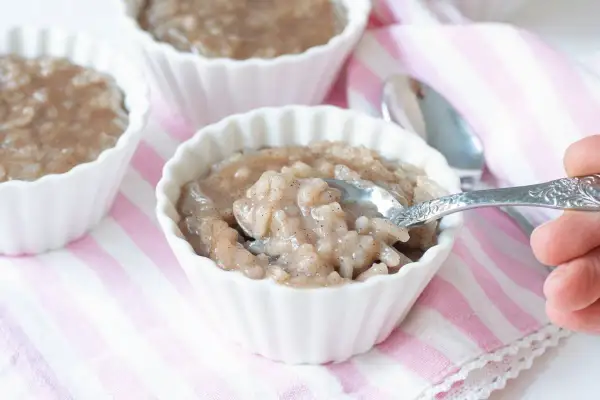 Delicioso arroz con leche de soja en cuencos blancos, con una cuchara lista para probar.